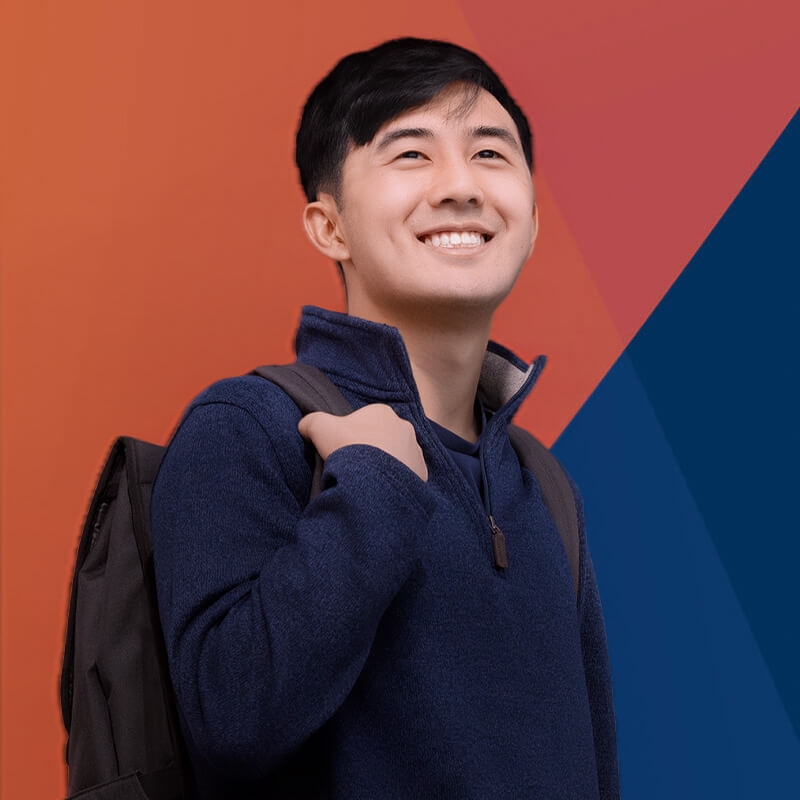 Man wearing a navy sweater and backpack, smiling and looking upward against an orange and blue background.